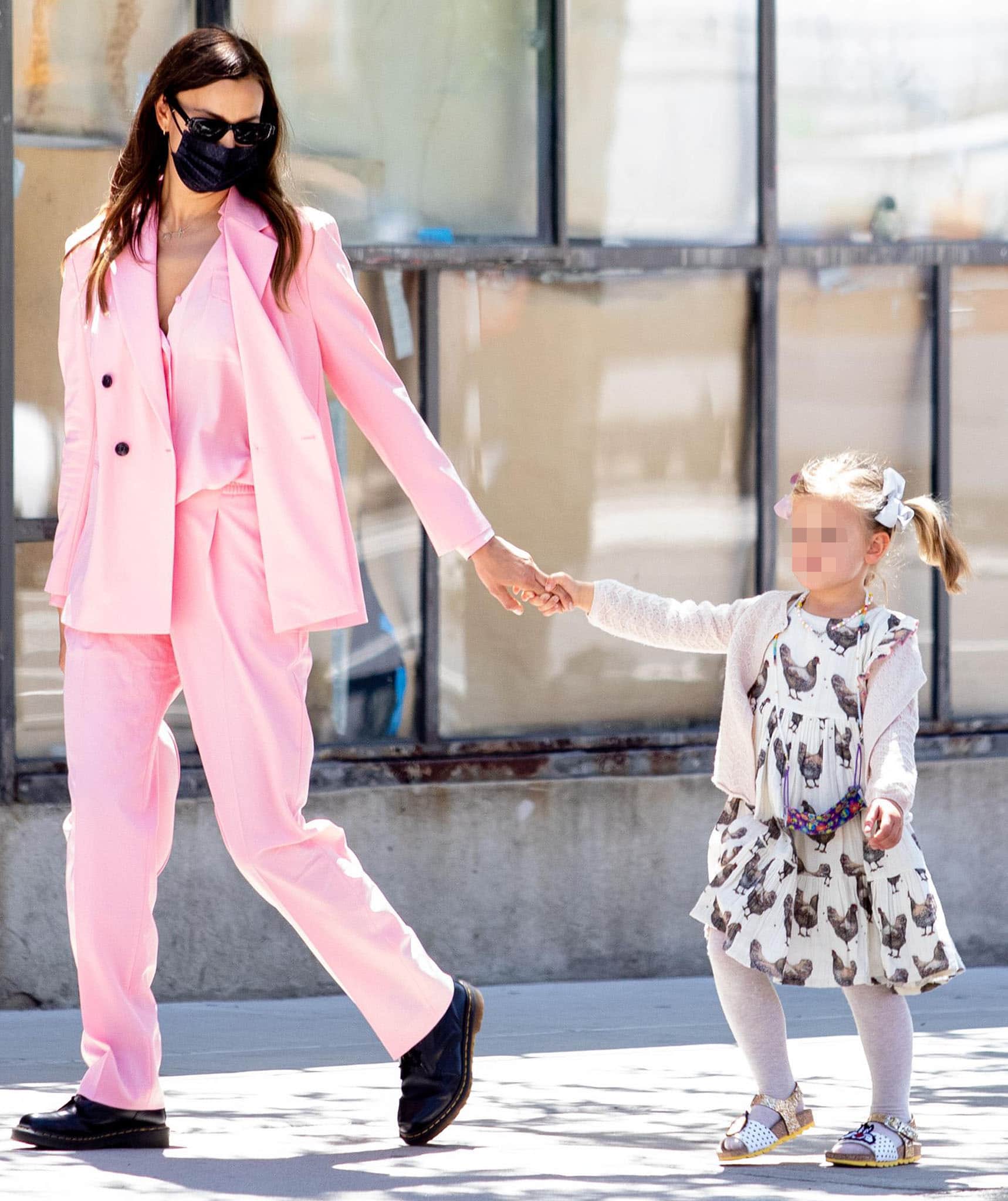 Irina Shayk balances a bubblegum-pink Hugo Boss suit with black Dr. Martens 1460 boots while walking daughter Lea in Greenwich Village