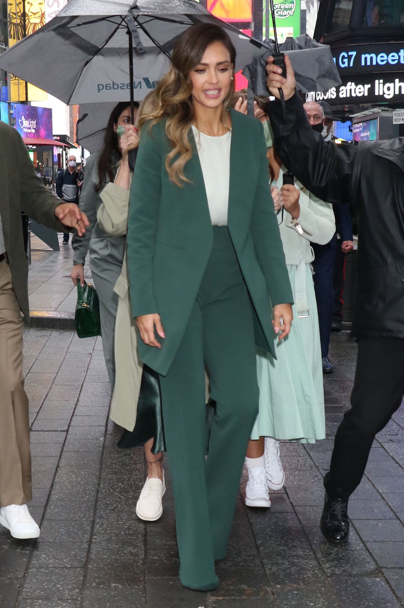 Jessica Alba navigated rainy Times Square in a sharply tailored Narciso Rodriguez emerald suit layered over a silky seafoam blouse