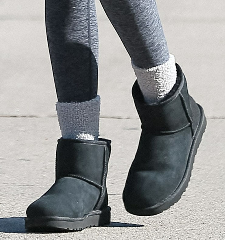 Kaia Gerber steps out in black UGG Classic Ultra Mini boots and slouchy gray socks, embracing the cozy footwear trend that quickly became a model-off-duty staple