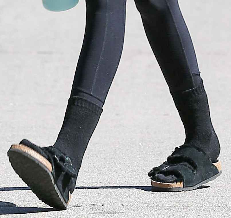 Kaia Gerber embraces the socks-and-sandals trend in black Birkenstock Arizona Shearling sandals, pairing the cozy footwear with black crew socks after a Pilates session