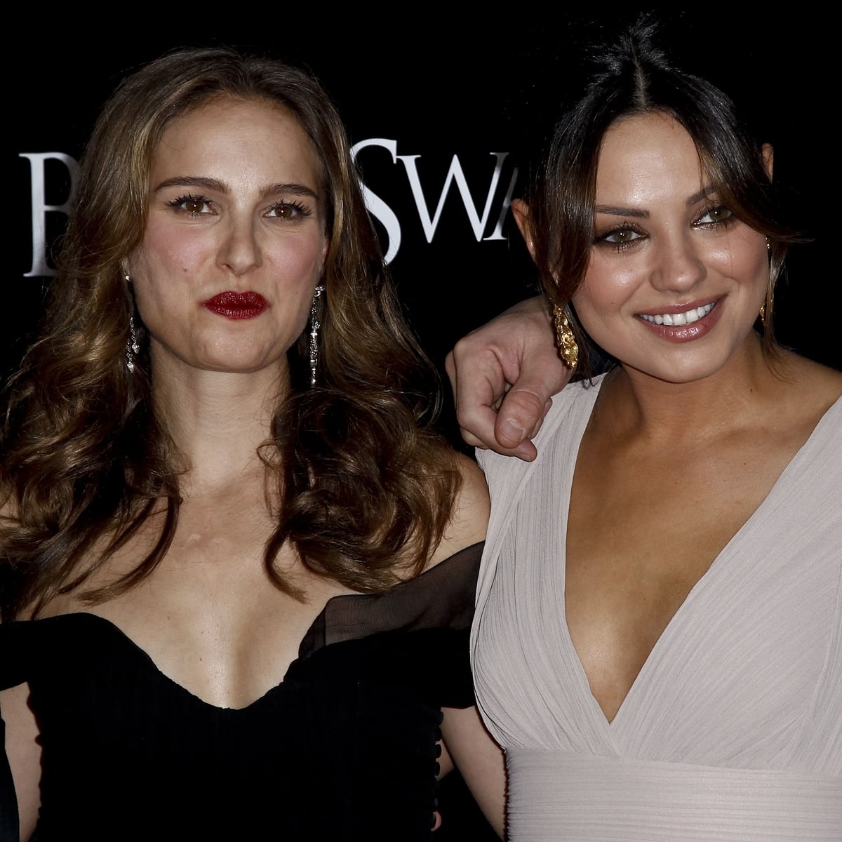 Natalie Portman radiates sophistication in an off-the-shoulder black gown, while Mila Kunis stuns in a plunging beige dress — the duo embodying Black Swan’s contrast of light and dark at the film’s New York premiere