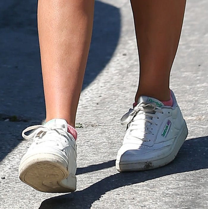Addison Rae pairs her athleisure outfit with Reebok Club C Vintage sneakers, complete with soft pink socks and a worn-in retro finish that nods to the brand’s classic tennis roots