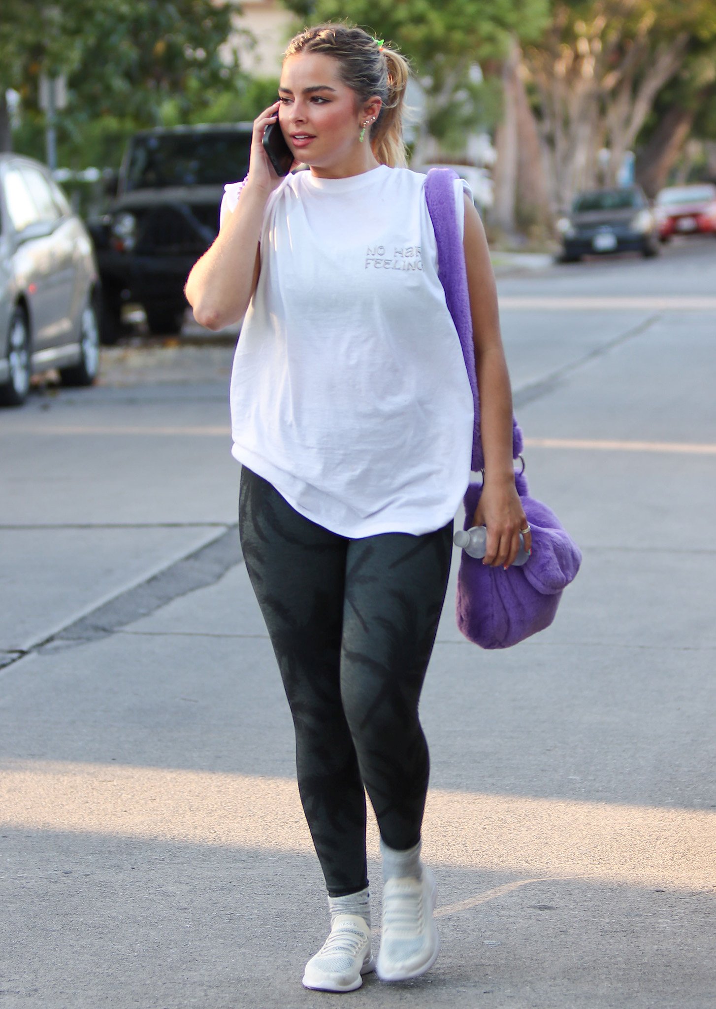 Addison Rae is seen leaving a workout session in Los Angeles on May 28, 2021, wearing sleek Tavi Noir high-waist leggings, a relaxed white “No Hard Feelings” tee, and white APL TechLoom Breeze sneakers that blended sporty function with minimalist streetwear flair