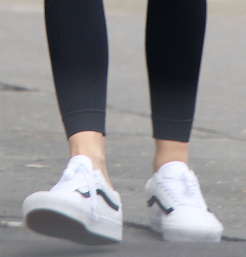 Her white Vans Old Skool sneakers deliver flexible, city-ready comfort with a vulcanized sole and padded collar, balancing the oversized layers with a streamlined, street-smart finish