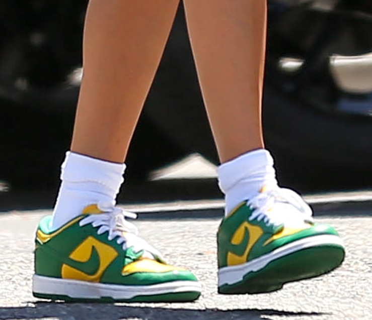 Hailey Bieber finishes her post-Pilates ensemble with Nike Dunk Low "Brazil" sneakers, using the green-and-yellow colorway to complement her vibrant Elder Statesman cardigan
