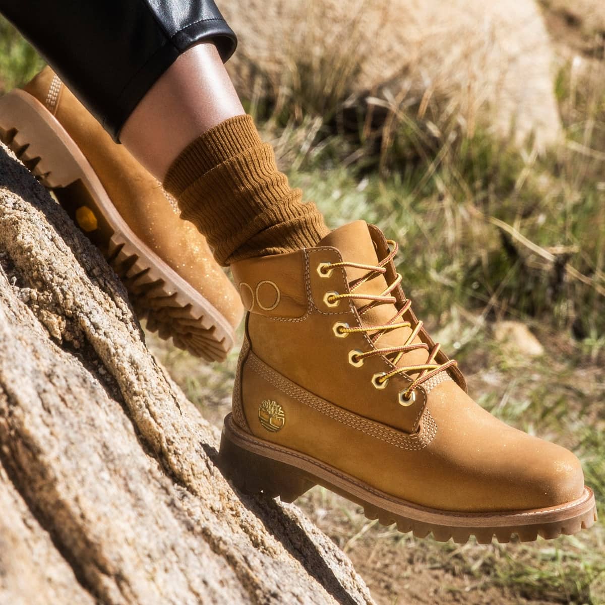 A close-up view showcases the wheat nubuck Jimmy Choo × Timberland boot’s sturdy lug sole, gold-tone hardware, and refined craftsmanship