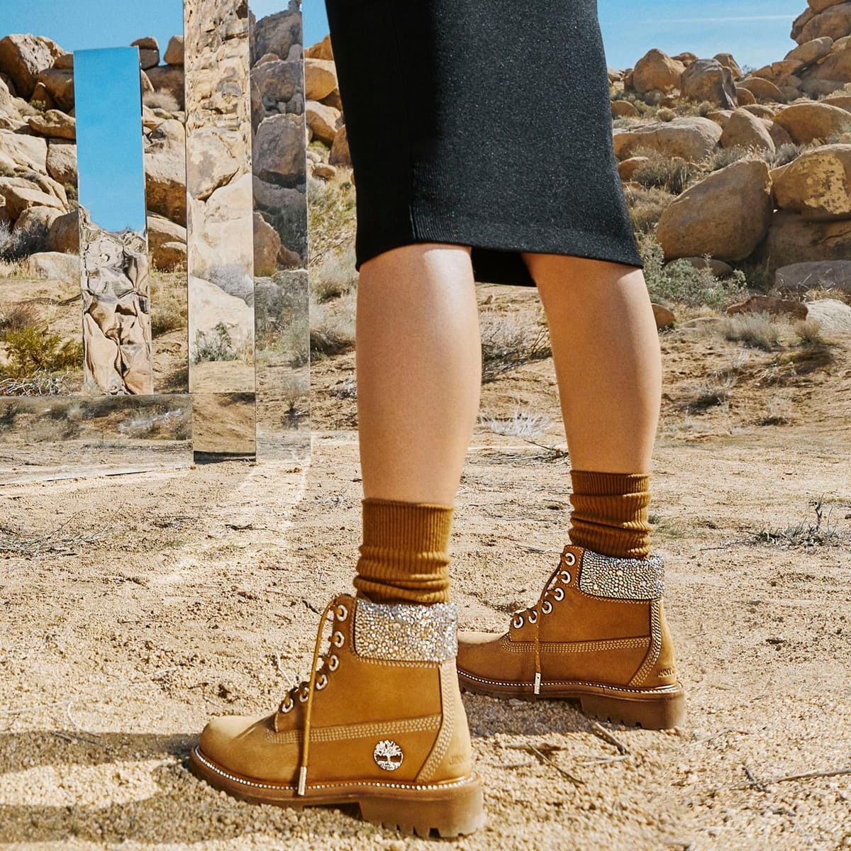 Styled with cuffed socks and a midi skirt, the crystal-collar Jimmy Choo × Timberland boots bring high-fashion sparkle to Timberland’s heritage work-boot design