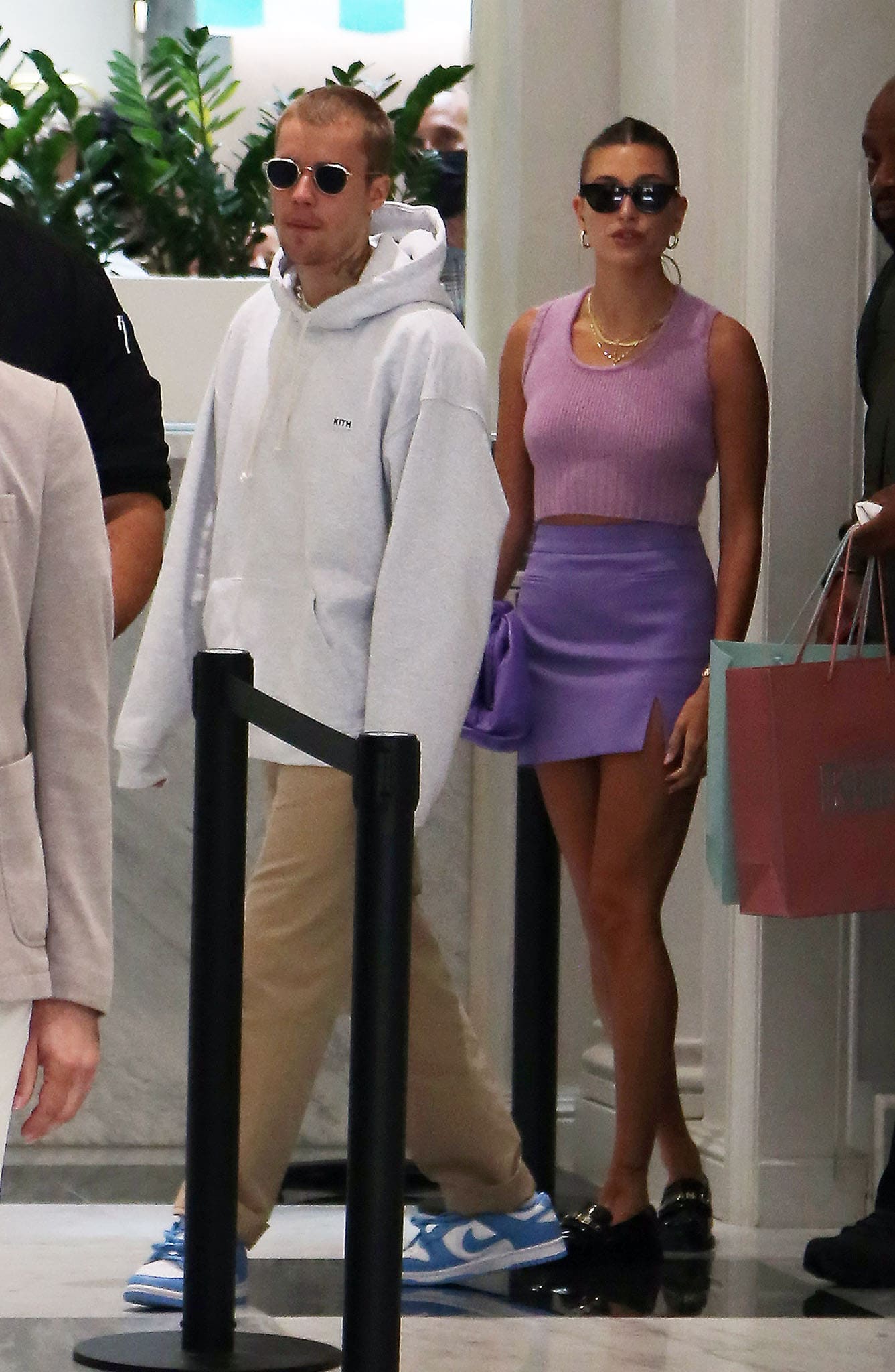 Justin and Hailey Bieber leave Kith in Paris on June 21, 2021, with Hailey styling a tonal lilac outfit with glossy black Chanel loafers while Justin keeps it casual in blue-and-white Nike Dunk sneakers