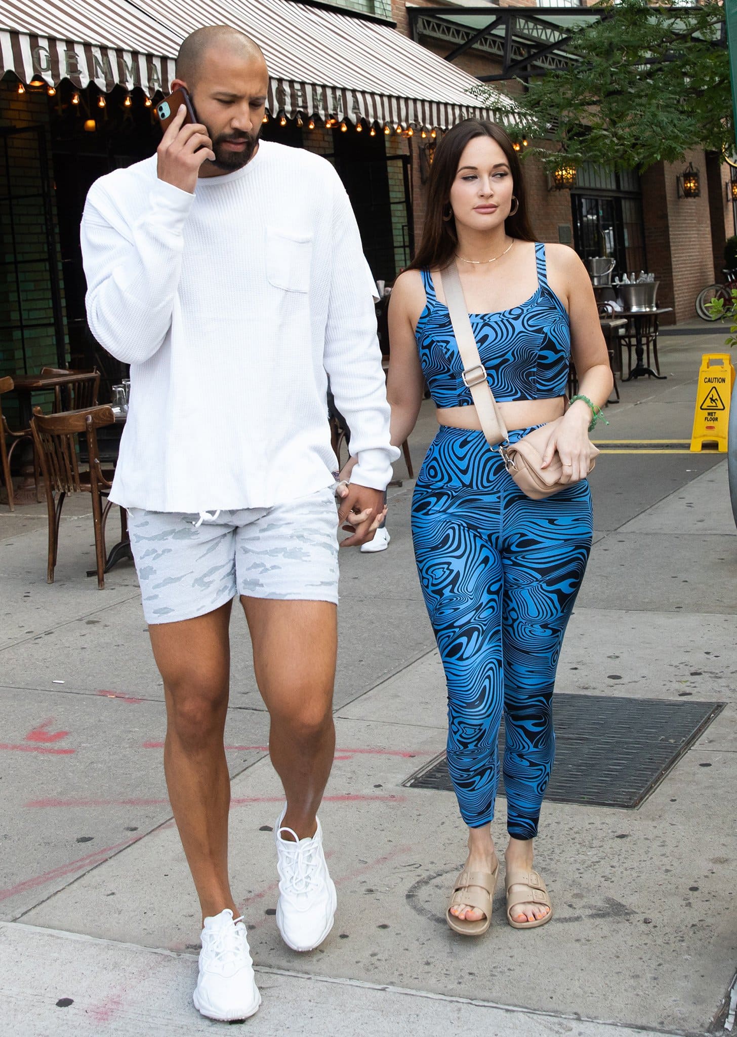 Kacey Musgraves pairs a blue swirl-print athleisure set with beige Freedom Moses "Moses" slides while walking hand in hand with writer Cole Schafer