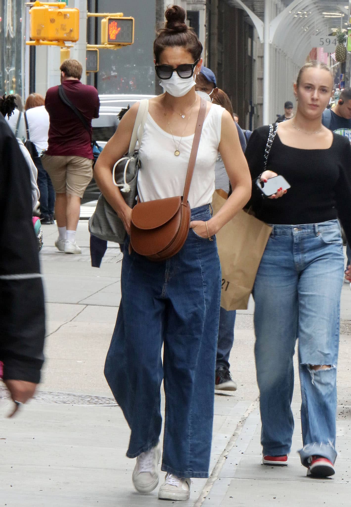 Katie Holmes' summer outfit includes an off-white tank top and a pair of baggy denim jeans