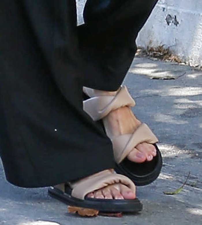 Kendall Jenner leans into the “ugly sandal” trend by finishing her relaxed menswear look with Alias Mae Paris slide sandals, balancing comfort-driven design with effortless street style