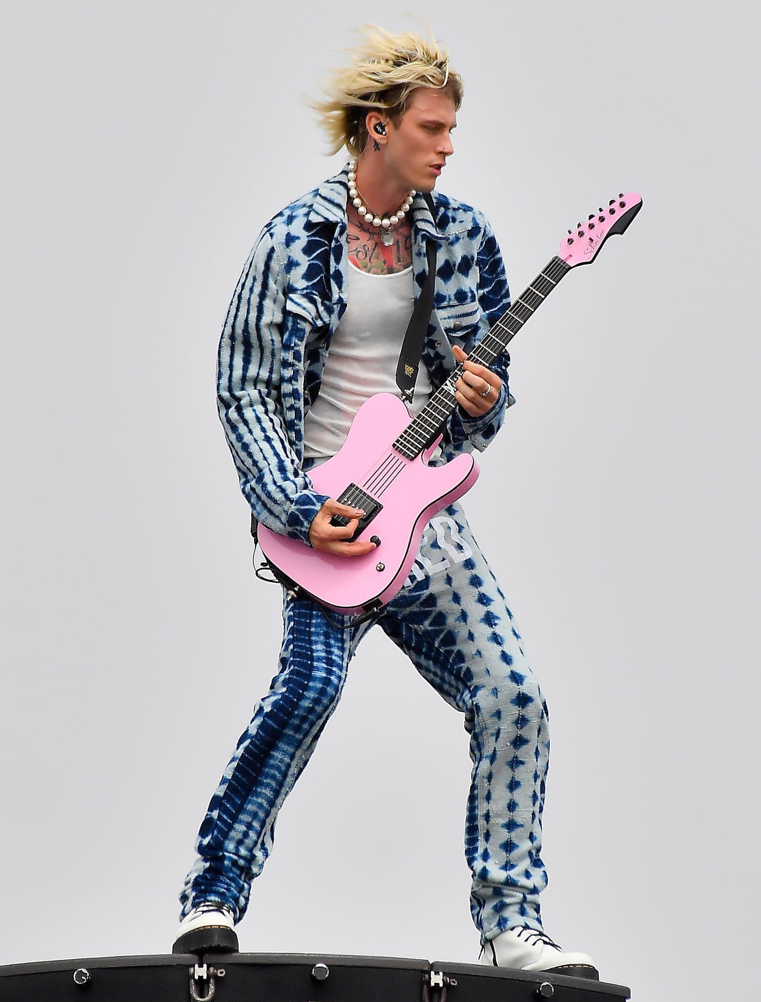 Machine Gun Kelly rocks a blue tie-dye ensemble and a pink guitar during his rooftop concert at Venice Beach