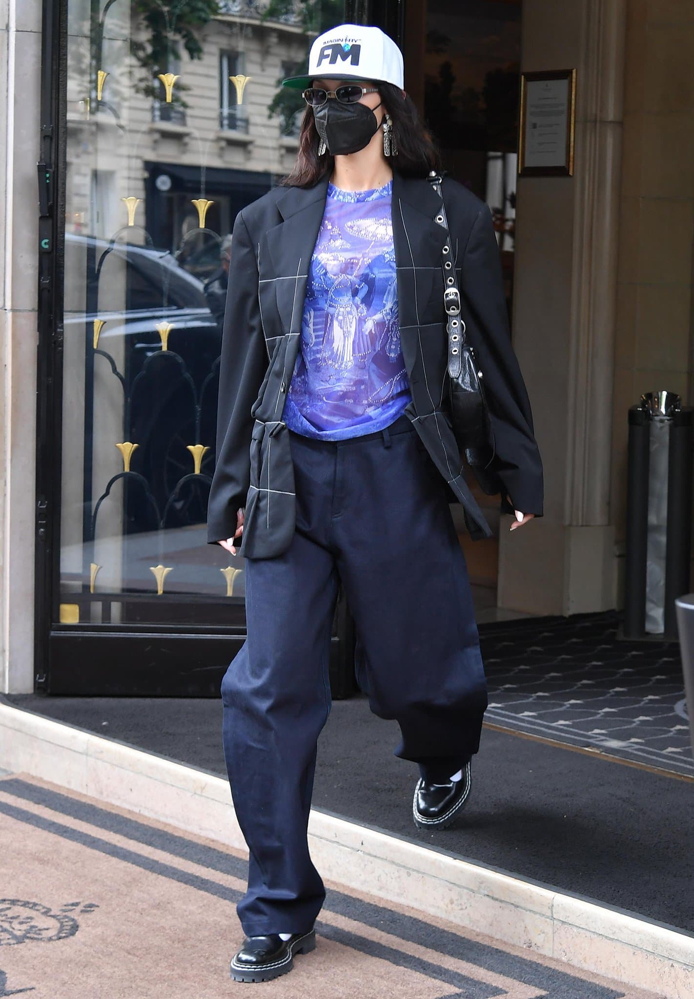 Bella Hadid leaves her Paris hotel to lunch at Ferdi in a quilted blazer with a sheer purple tee and baggy pants