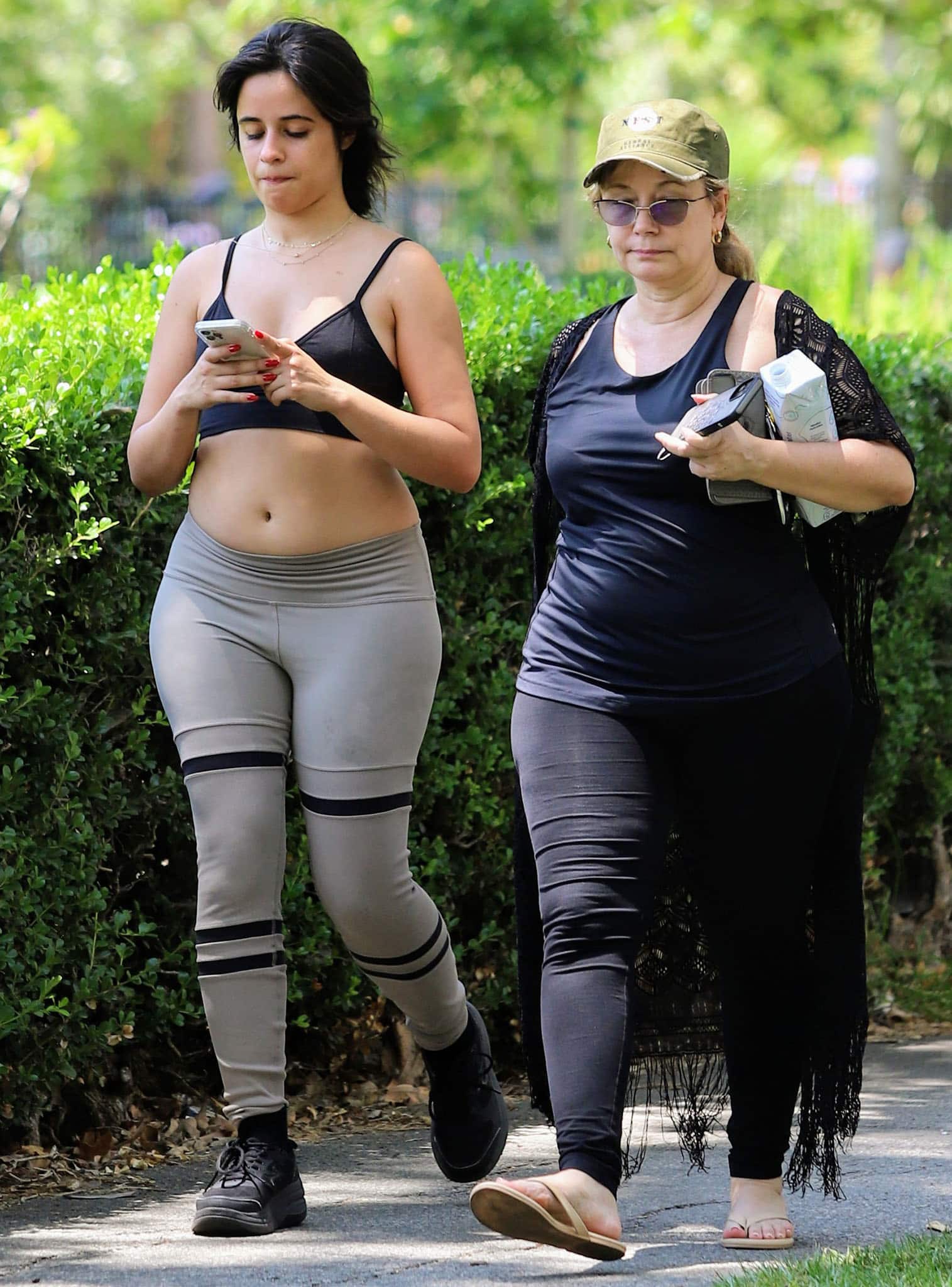 Camila Cabello keeps her workout look relaxed and practical while walking with her mother, Sinuhe Estrabao, at a Los Angeles park on July 16, 2021, pairing chunky black sneakers with Alo Yoga activewear for a casual off-duty fitness outfit