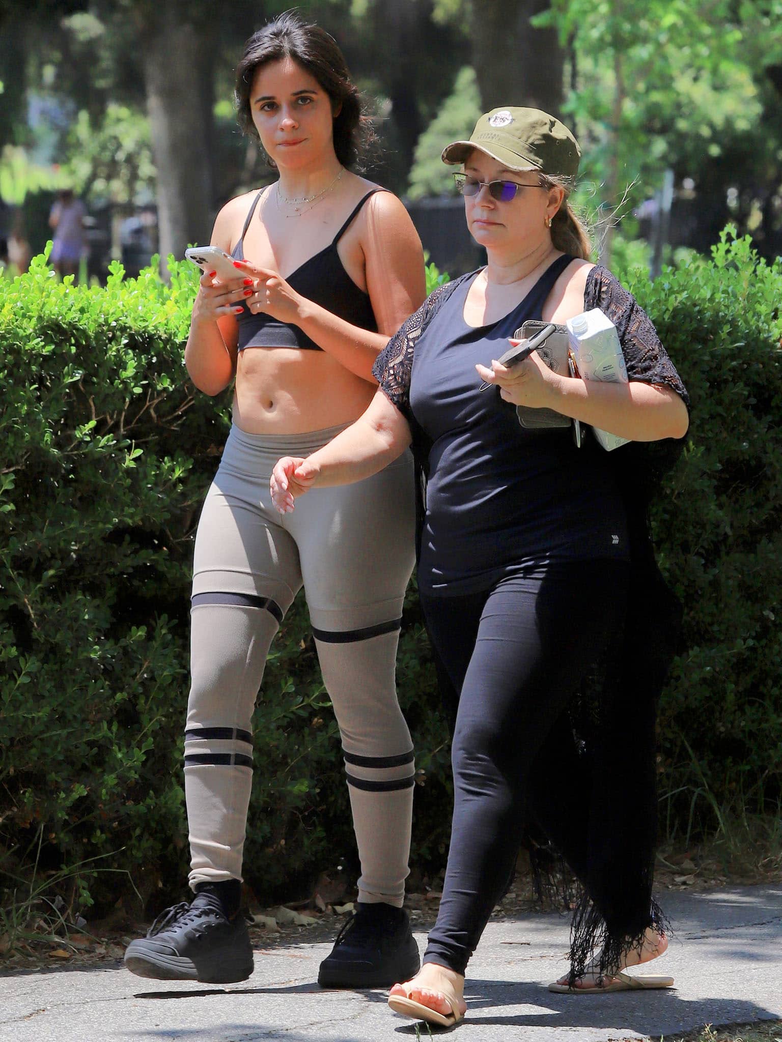 Sinuhe Estrabao keeps her workout outfit practical in black leggings, flip-flops, and a lightweight lace-trim cardigan while walking alongside daughter Camila Cabello at a Los Angeles park