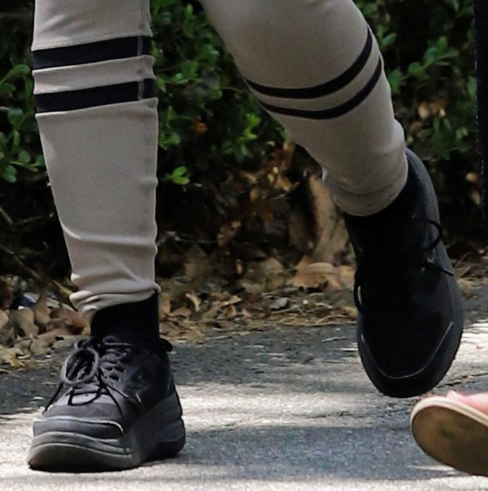 Camila Cabello grounds her monochrome workout look with black crew socks and chunky platform sneakers, adding a sporty finish to the sleek Alo Yoga leggings