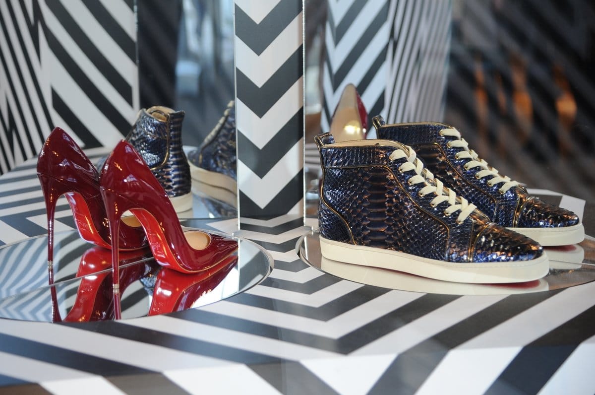 Christian Louboutin’s signature red-soled pumps and textured python-effect sneakers showcased inside his boutique at Selfridges Exchange Square in Manchester