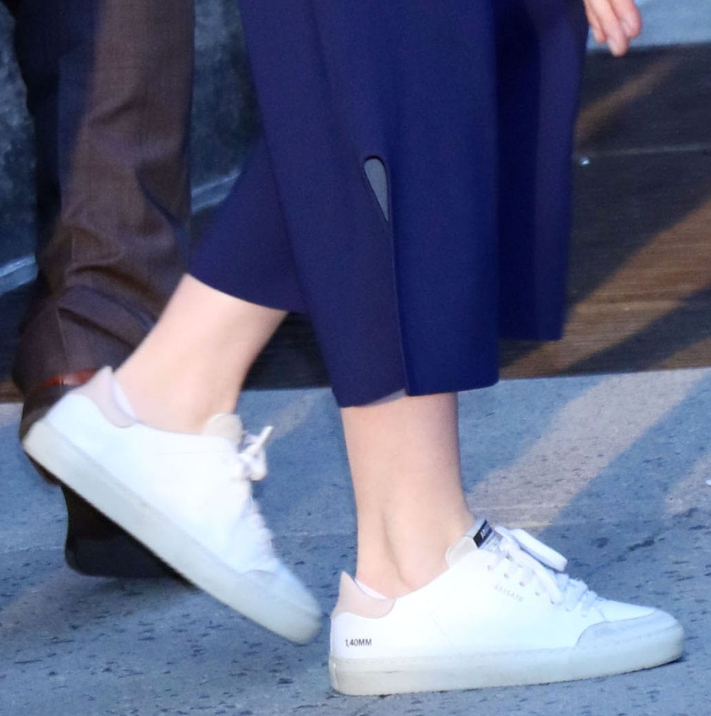 Emily Blunt completed her navy Stella McCartney ensemble with white Axel Arigato Clean 90 Triple leather sneakers featuring contrasting gray suede toe caps and blush-pink heel tabs