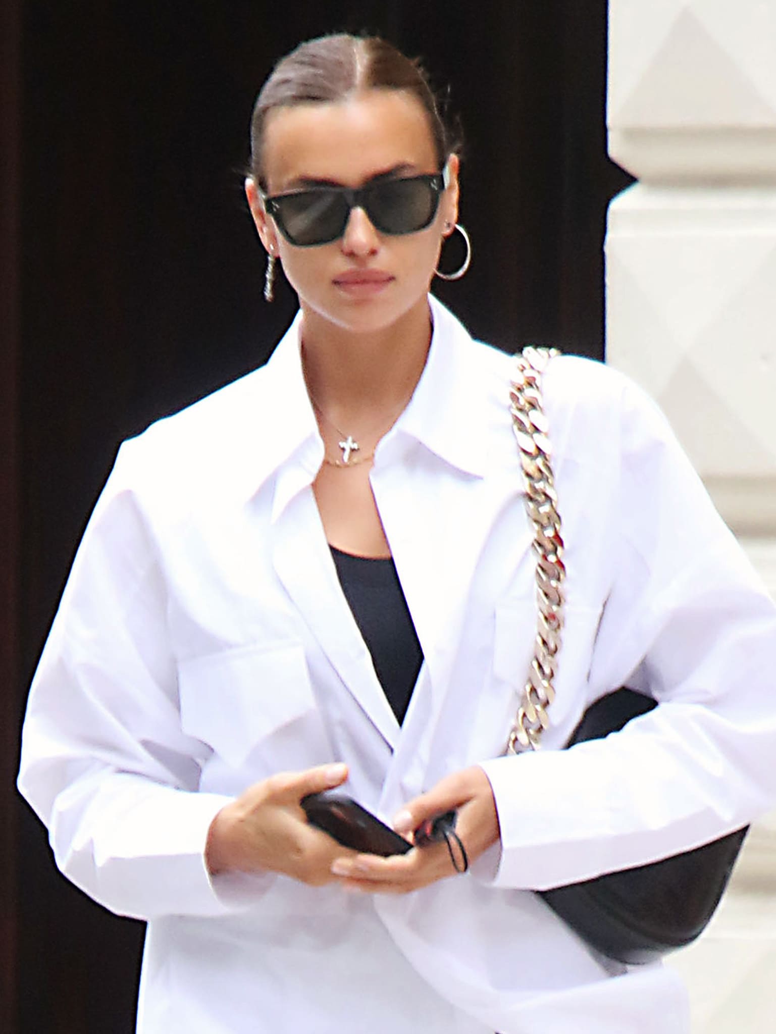 Irina Shayk keeps her beauty look effortless with a sleek, center-parted bun, barely-there makeup, and streamlined accessories that complement her polished street-style outfit