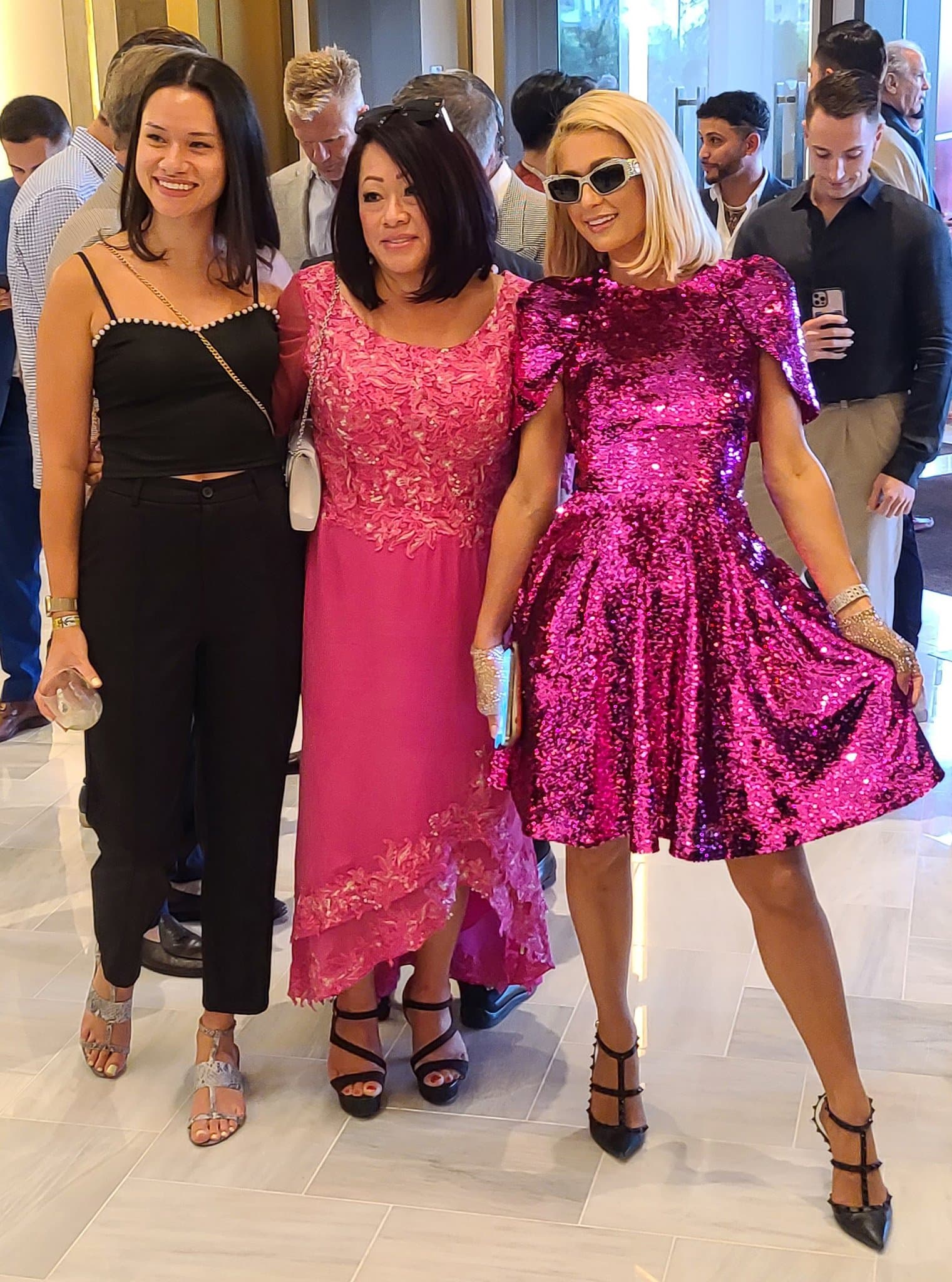 Paris Hilton pairs a fuchsia sequined Pamella Roland mini dress with black Valentino Garavani Rockstud caged pumps