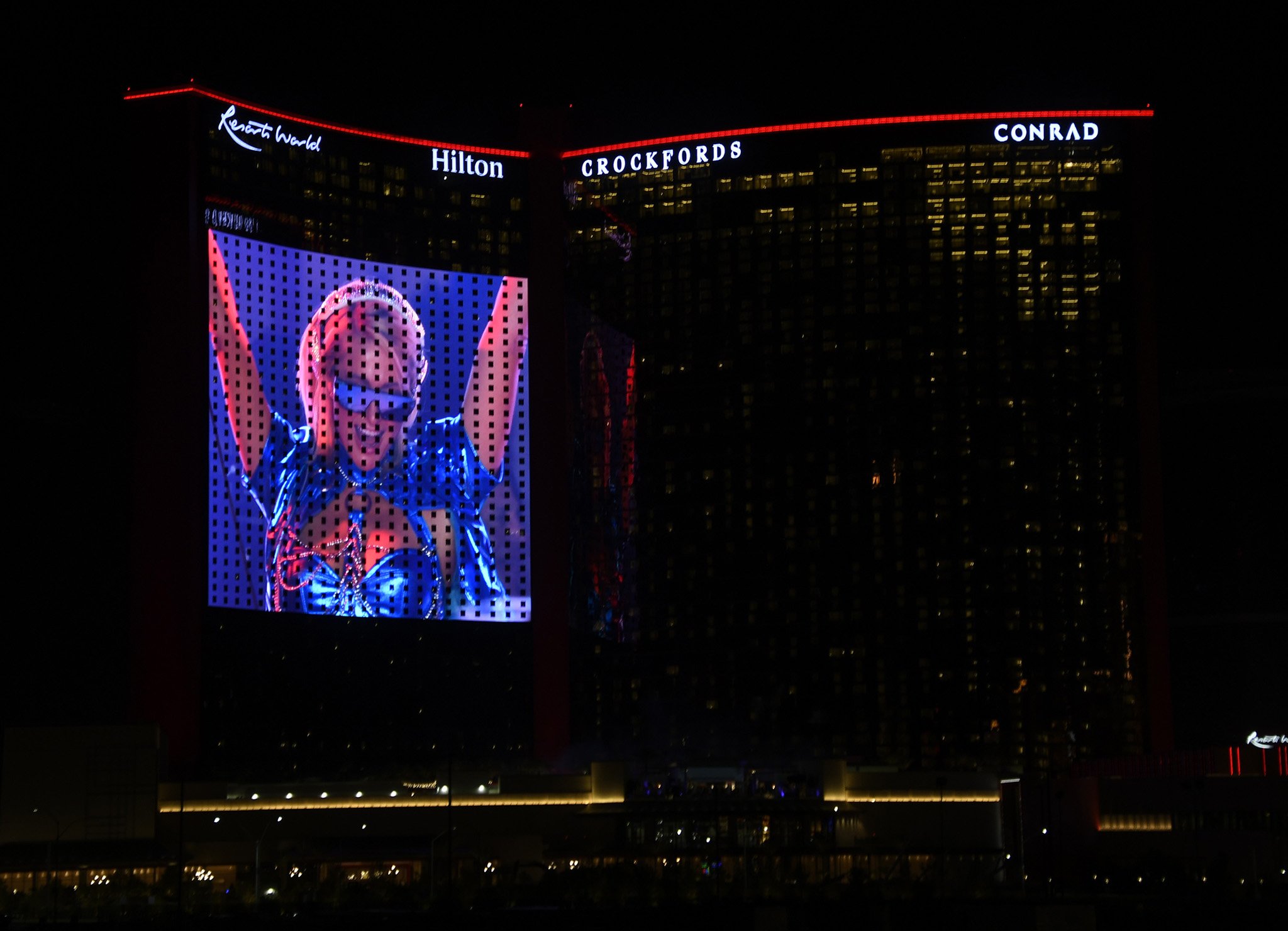 Paris Hilton is seen DJing on the big screen during the grand opening of Resorts World Las Vegas on June 24, 2021