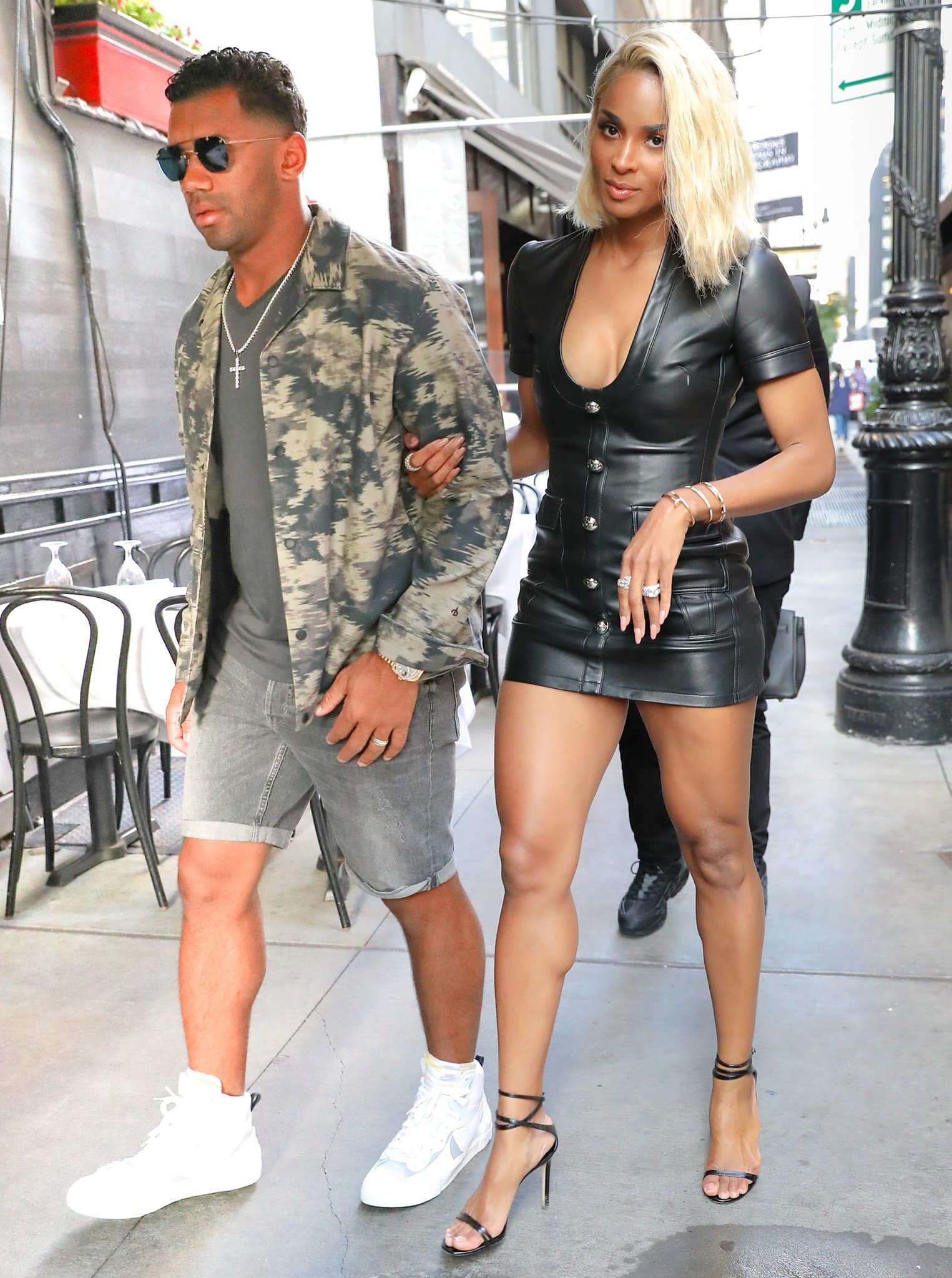 Ciara turns heads in a sleek black leather mini dress paired with delicate black ankle-strap stiletto sandals as she steps out arm-in-arm with Russell Wilson for a chic date night at Philippe Chow in New York City on June 30, 2021