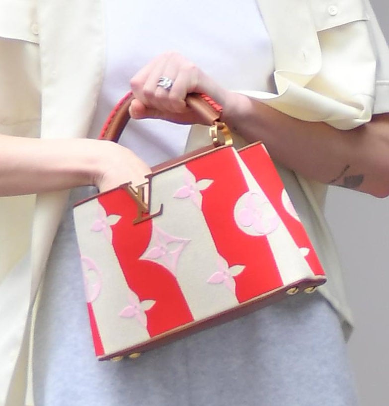 Sophie Turner punctuates her relaxed street-style look with a red-and-cream Louis Vuitton Capucines BB bag, its oversized Monogram motifs and gold-tone LV hardware adding a bold pop of color and polish