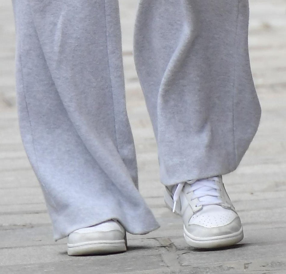 Sophie Turner grounds her relaxed gray sweats with Nike Dunk Low “Photon Dust” sneakers, the crisp white leather and soft gray overlays adding clean, minimalist polish to her off-duty Paris look
