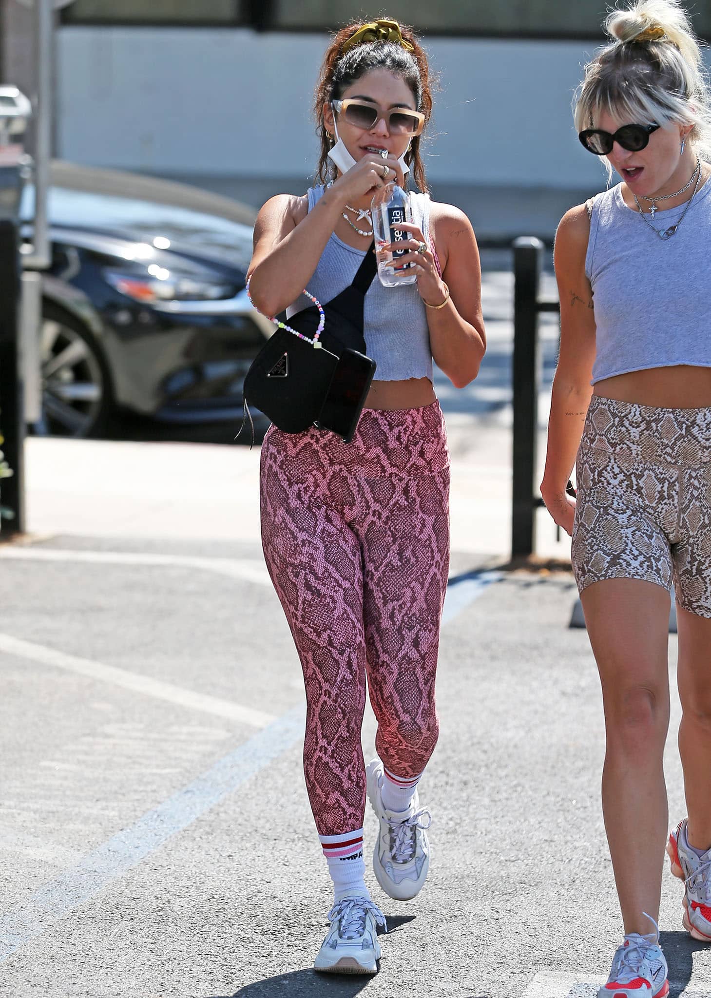 Vanessa Hudgens pairs a gray cropped tank with pink snakeskin leggings, finishing the gym-ready look with striped crew socks and Mercer Amsterdam Jupiter sneakers