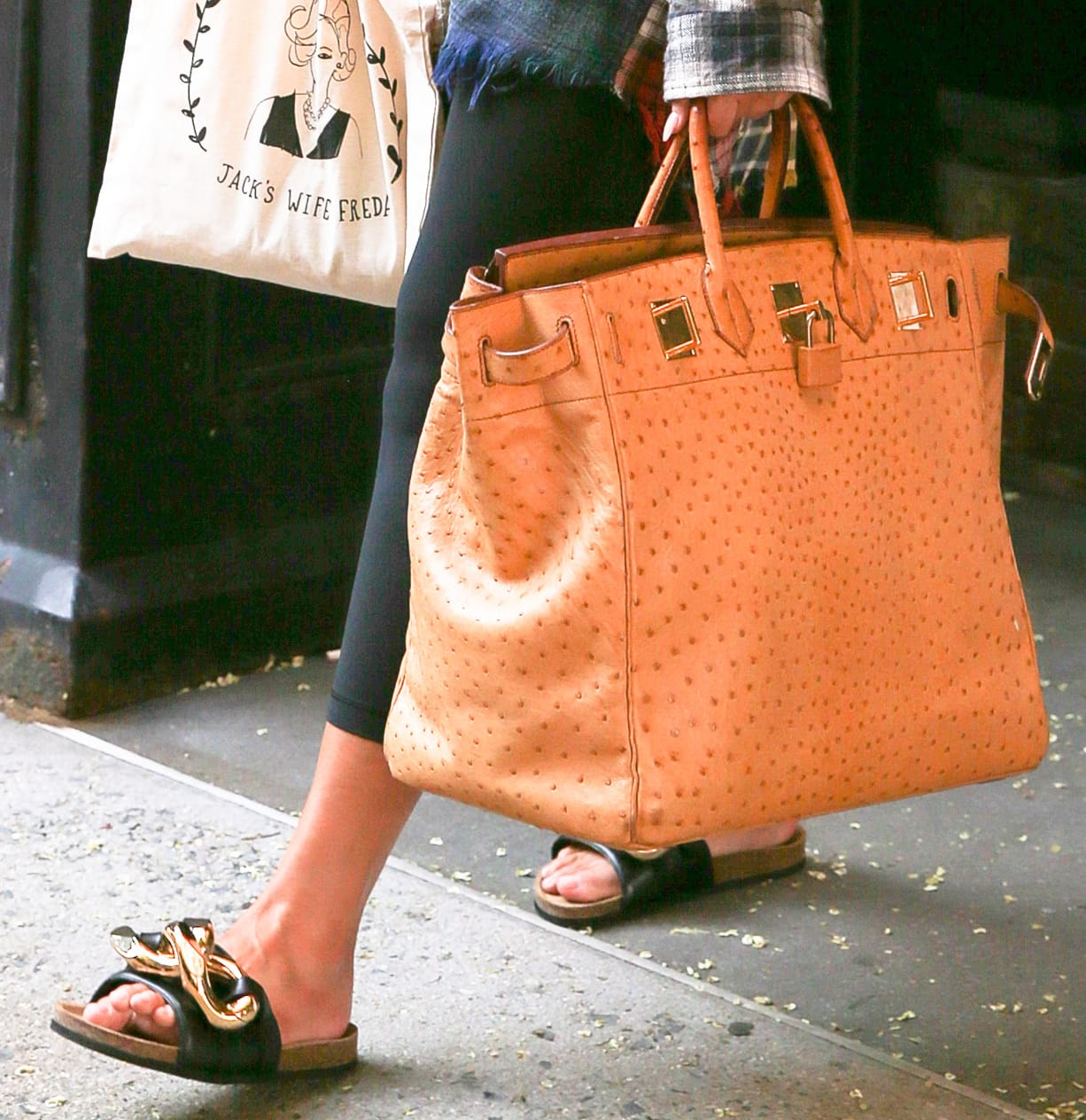 Chrissy Teigen completes her laid-back Soho look with JW Anderson Chain slides and an oversized Hermès Birkin bag