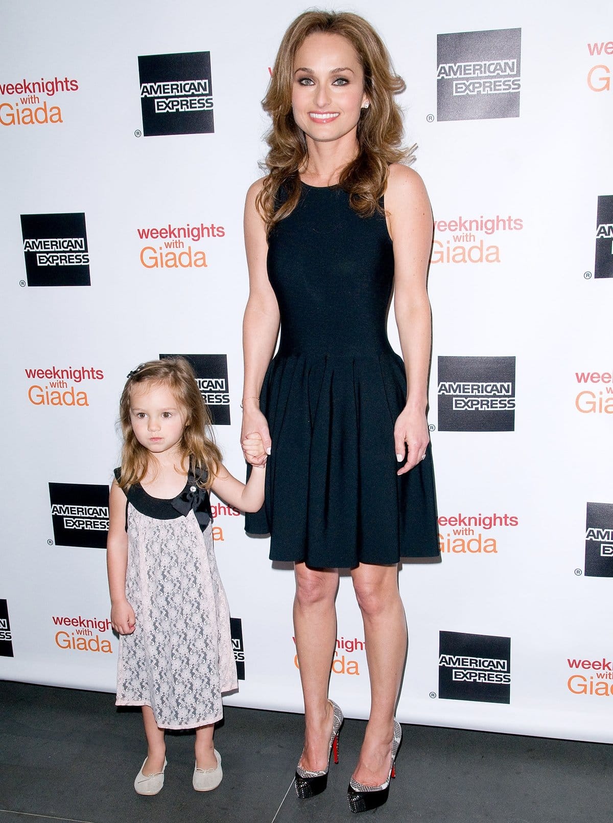 Jade Marie De Laurentiis Thompson and her mother, Giada De Laurentiis, attend the “Weeknights With Giada” book launch in coordinating dresses, with Giada elongating her petite frame in glitter-accented black peep-toe Christian Louboutin heels