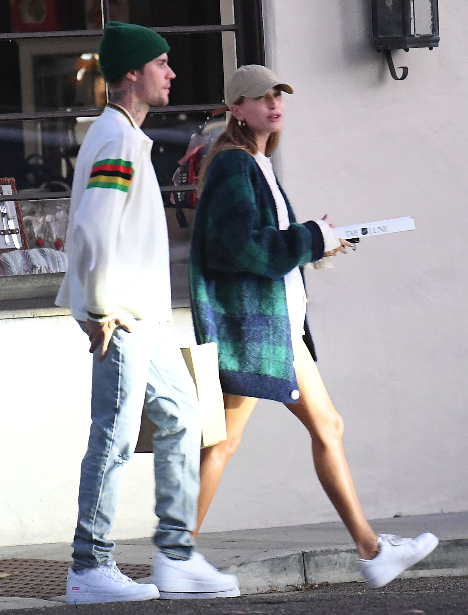 Hailey Bieber wearing an Alessandra Rich plaid cardigan with white Nike Air Force 1 sneakers