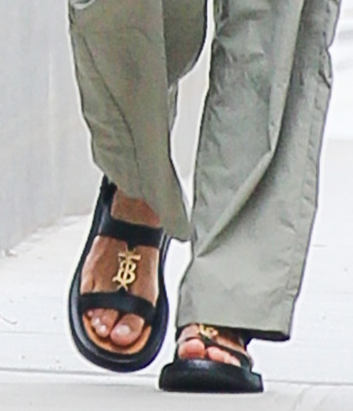 Irina Shayk’s Burberry sandals feature thick leather straps, a contoured footbed, and a raised flatform sole, with the gold TB logo anchoring the open-toe design in signature house branding