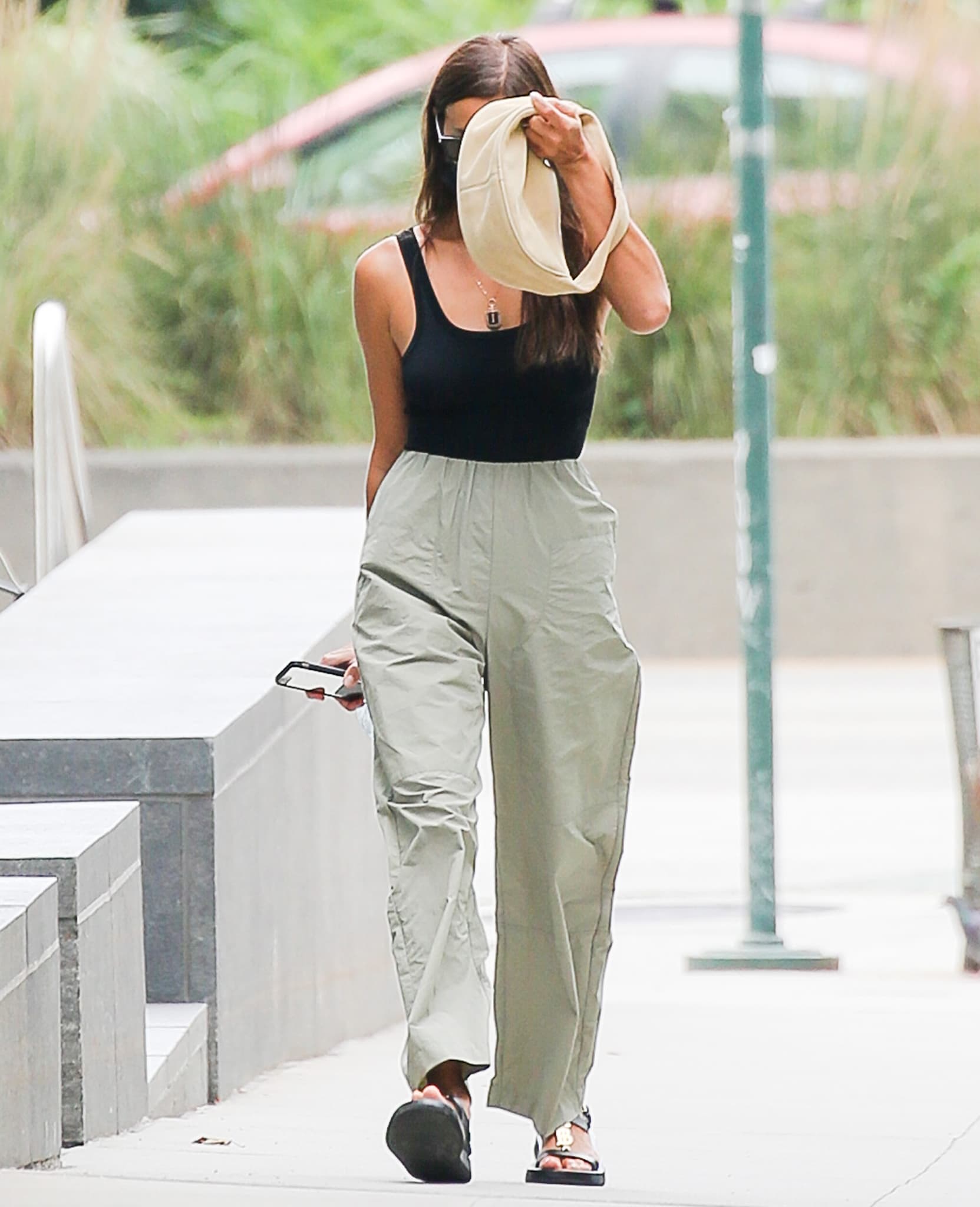Walking through New York City, Irina Shayk highlights the versatility of her Burberry sandals, pairing the utilitarian flatforms with a streamlined bodysuit and loose, movement-driven tailoring