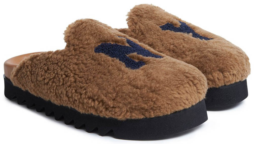 Joshua Sanders' brown NY mules reinterpret the classic house slipper with plush shearling, bold collegiate lettering, and an elevated lug-inspired sole