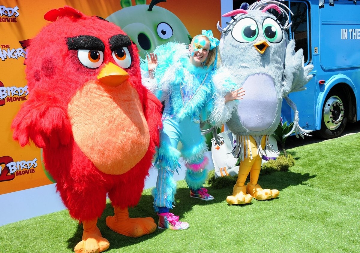 JoJo Siwa embraces her signature sparkle in pastel feathered layers and glitter-drenched high-top sneakers as she celebrates her voice role as Eagle Island resident Kira at The Angry Birds Movie 2 promotional event