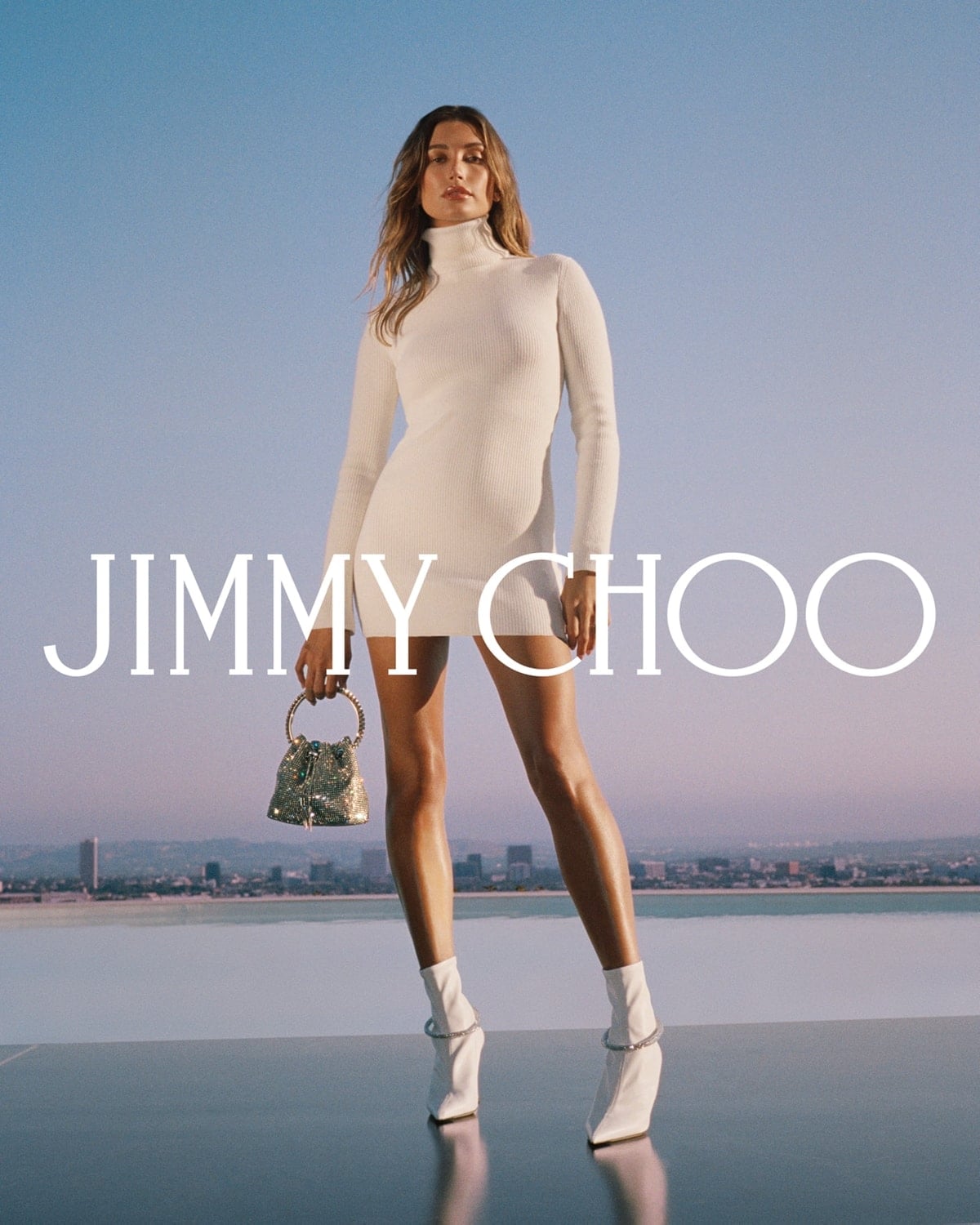 Hailey Bieber wears a white turtleneck dress and matching sock boots that match like a glove