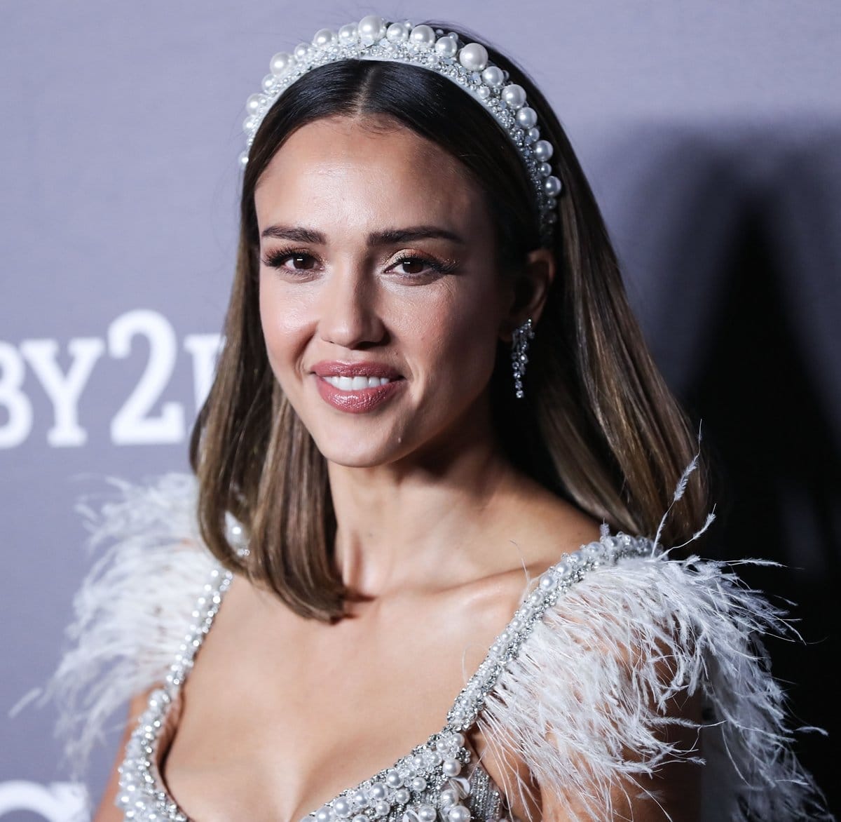 Jessica Alba radiates elegance in a pearl-embellished ensemble, complementing her look with three sets of dazzling diamond earrings from Anita Ko for a touch of timeless glamour