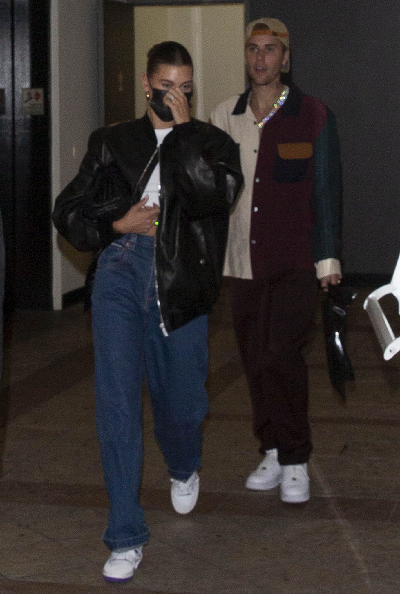 Hailey channels laid-back ’90s cool in Eytys baggy jeans, a Magda Butrym leather bomber, and purple-trimmed New Balance 550 sneakers, while Justin coordinates in a retro color-block shirt, relaxed trousers, and Nike Air Force 1s in West Hollywood
