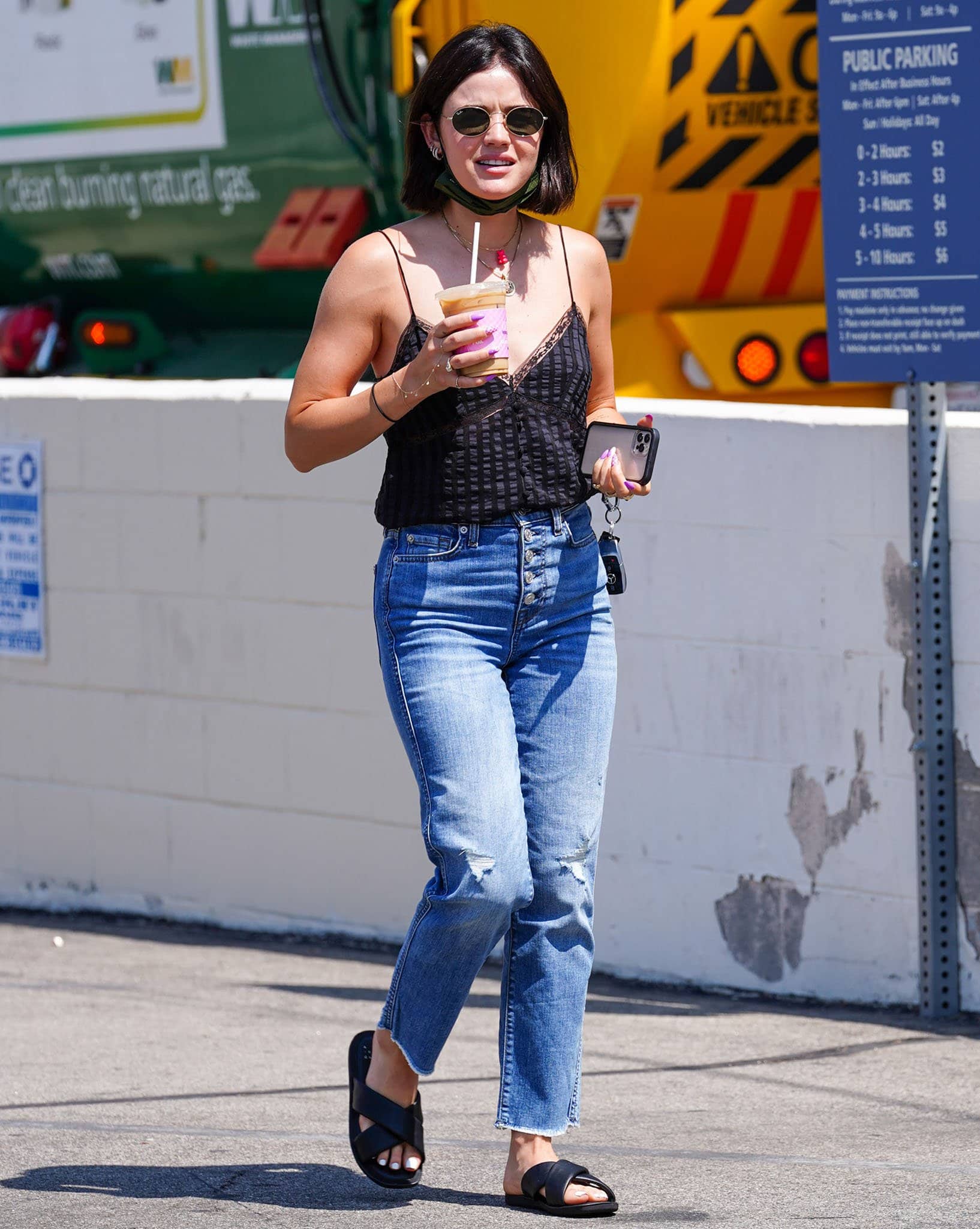 Lucy Hale pairs black padded crossover leather slides with an Anine Bing camisole and button-fly jeans while grabbing coffee in Los Angeles on August 30, 2021