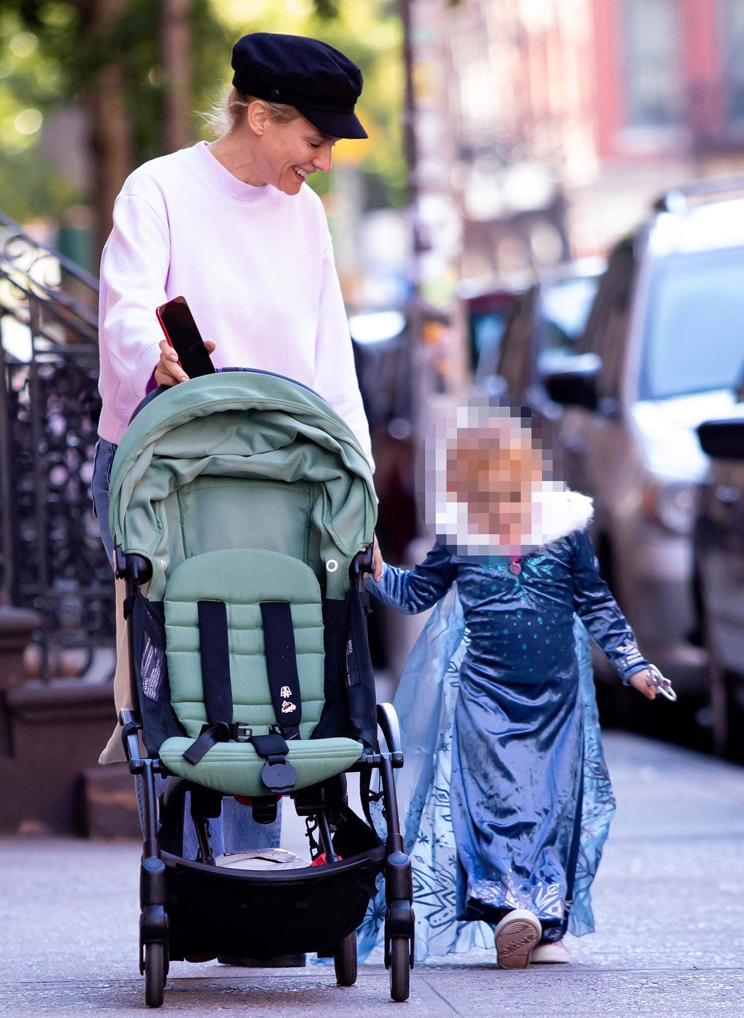 Diane Kruger embraces relaxed off-duty style while out in New York, pairing a soft pastel sweatshirt and casual denim with a baker-boy cap as she holds hands with her daughter, who’s dressed in a flowing princess costume