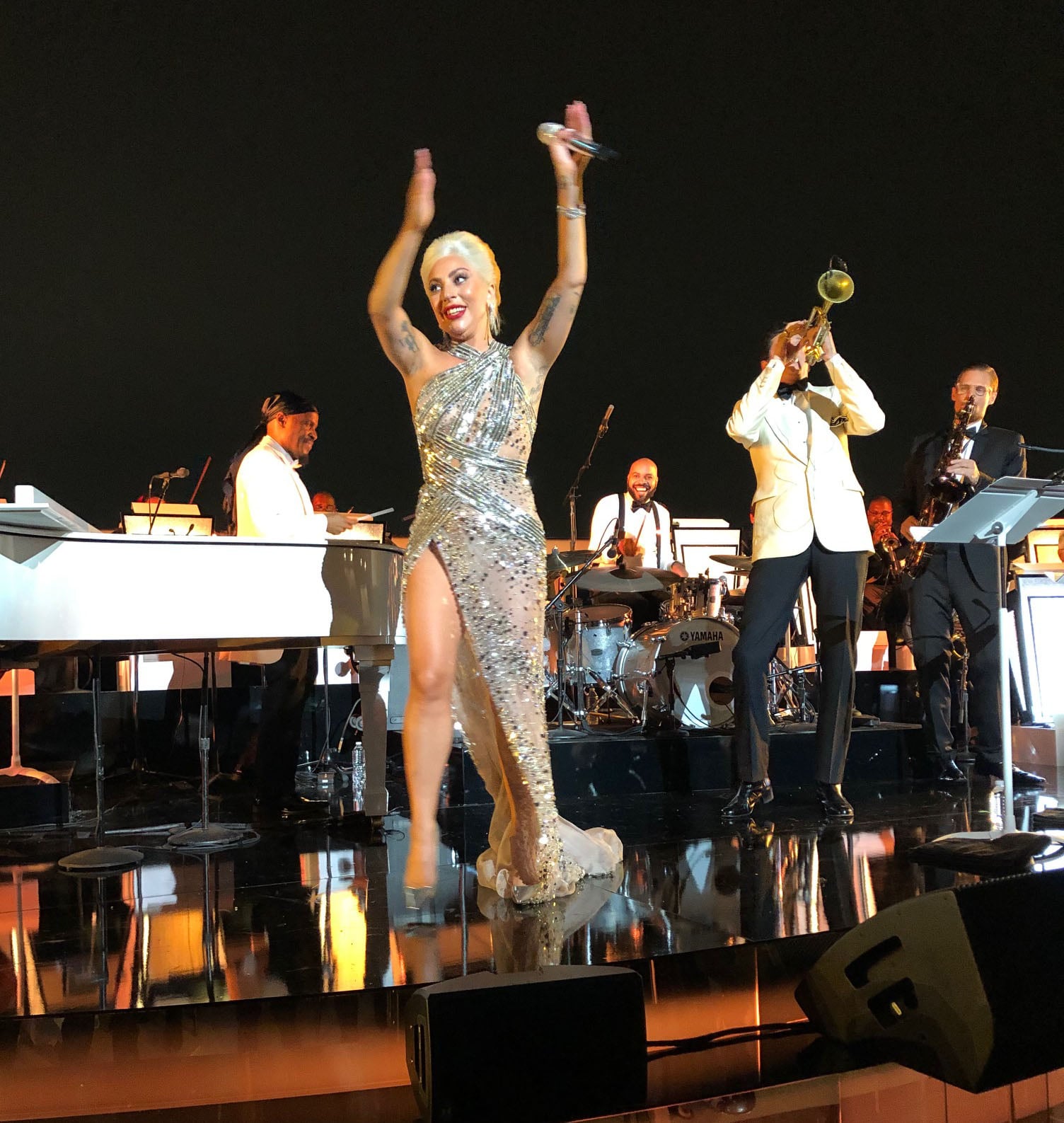 Lady Gaga’s metallic Jimmy Choo stilettos flash beneath her crystal-covered Elie Saab gown as she performs during the Academy Museum’s opening gala