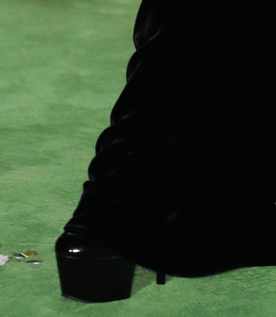 A glimpse beneath Lady Gaga’s floor-length Schiaparelli gown reveals the towering black Pleaser Xtreme-1020 platform boots hidden under the red carpet look