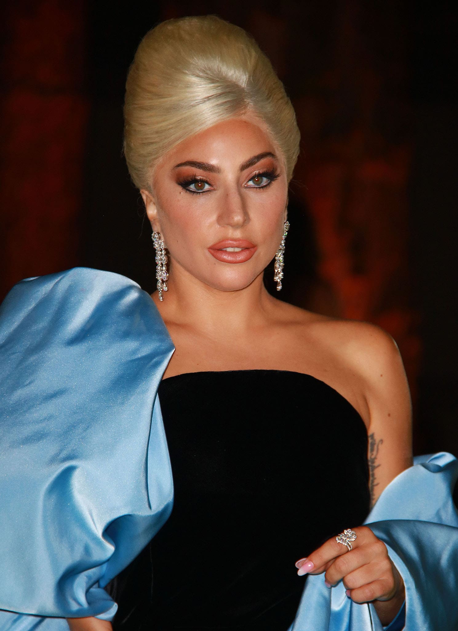 Lady Gaga completes her vintage-inspired beauty look with a blonde beehive, smoky winged eyes, Chopard diamond drop earrings, and a Precious Lace Collection ring