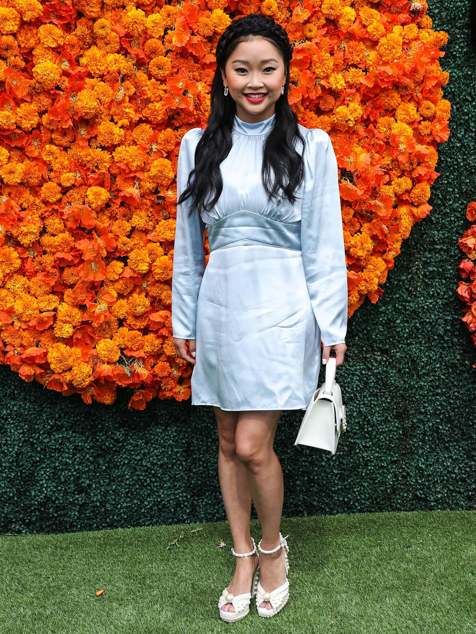 Lana Condor pairs her light-blue satin mini dress with pearl-embellished Jimmy Choo platform sandals, using the towering heels to add height and balance to her petite frame while keeping the look polished and playful