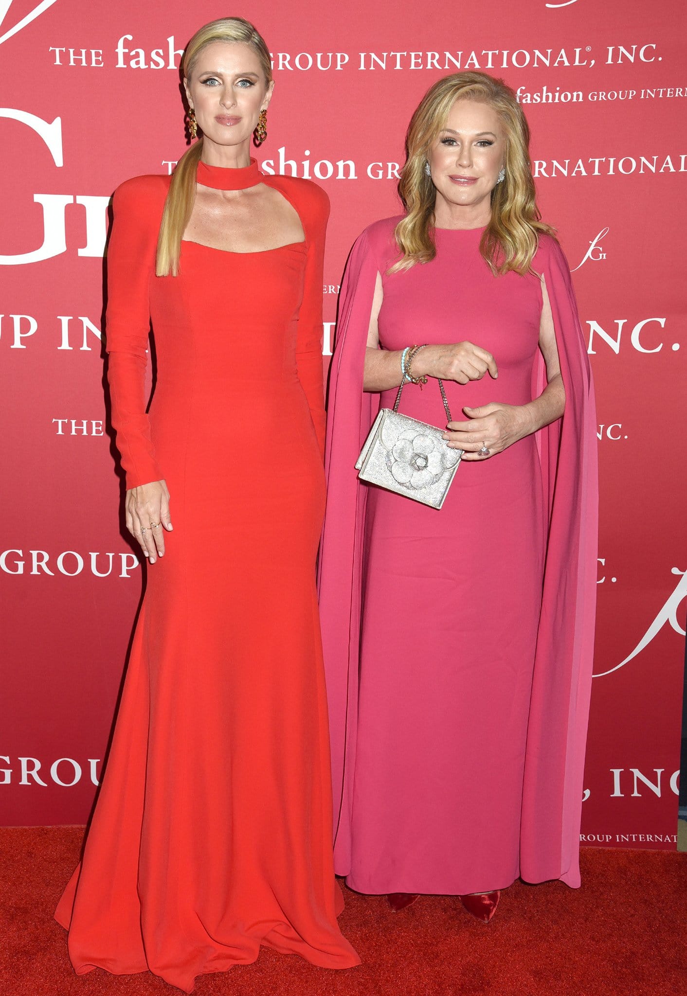 Nicky Hilton and her mother, Kathy Hilton, attend Fashion Group International’s 2021 Night of Stars gala at Cipriani South Street in New York City on October 13, 2021, coordinating in striking red and pink evening gowns