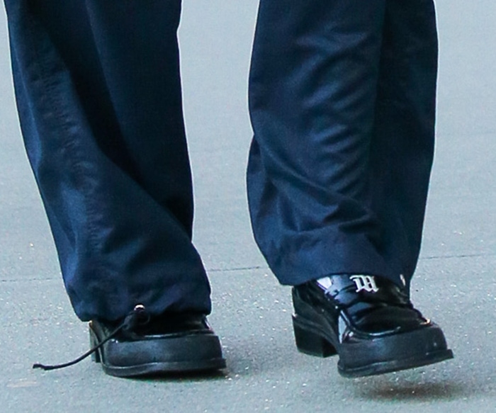 A closer look at Bella Hadid’s black Prada leather loafers, featuring a chunky sole, block heel, and the Italian fashion house’s signature triangle logo across the vamp