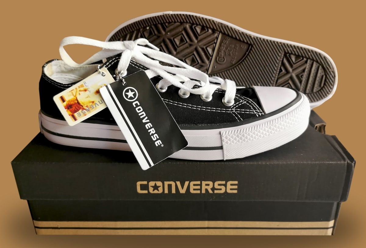 Authentic black Converse Chuck Taylor All Star low-top sneakers displayed with retail packaging featuring the brand’s iconic logo
