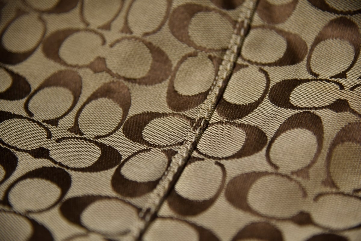 A magnified look at Coach’s Signature “C” jacquard pattern and precise stitching, a hallmark of authentic construction that counterfeit versions rarely replicate perfectly