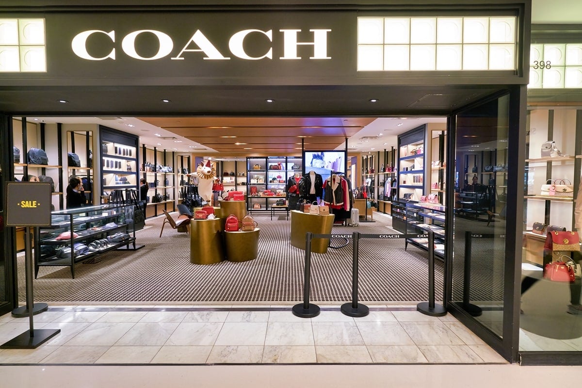 The Coach store showcases the brand’s signature aesthetic—sleek displays of leather handbags, shoes, and accessories that highlight its blend of modern American craftsmanship and timeless style